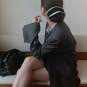 Detail showing mint green trimmed black scrunchie on model with oversized blazer