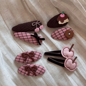 Detail of 7-piece children's hair clip set with pink fabric bows and cherry embroidery