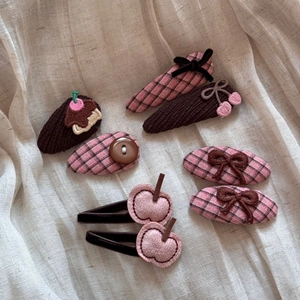 Flat lay of vintage style kids hair clips featuring corduroy fabric and cute embroidery