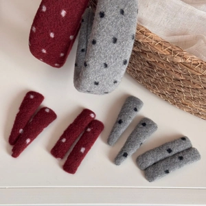 Detailed view of red and grey polka dot wool hairbands and matching hair clips set