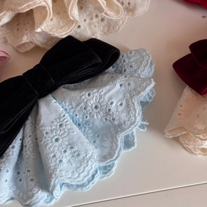 Dettaglio di fermagli per capelli in velluto con ricami floreali e pizzo delicato