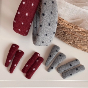 Close-up of wool felt polka dot headbands and hair clips in red and grey colors
