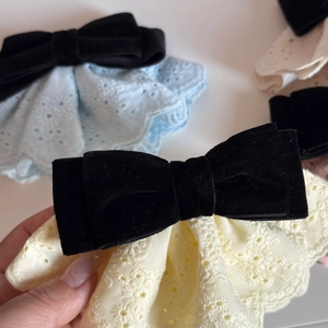 Dettaglio del fermaglio per capelli in velluto nero con ricamo floreale in pizzo fine