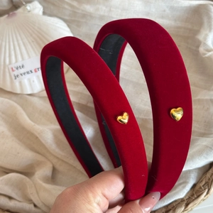 Detail shot of vintage red velvet headbands with small golden heart metal charms