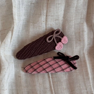 Detail of sweet fabric BB hair clips with cherry embroidery and velvet bow accents