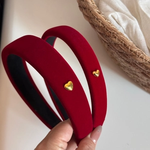 Detailed macro of red velvet headbands featuring golden heart-shaped metal buckles