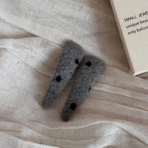 Detail of wool felt hair clips with polka dots on elegant linen background