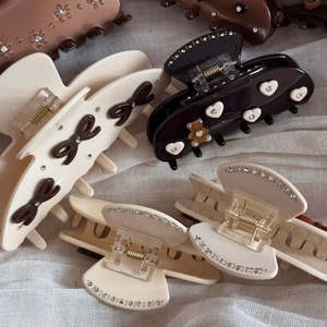 Detail showing various elegant acetate claw clips with rhinestones and ribbon patterns