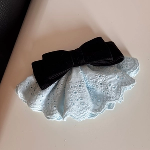 Dettaglio del fermaglio per capelli in velluto con pizzo blu e ricamo floreale