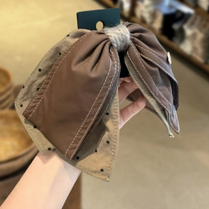 Retro bow hair clip with brown faux leather and polka dot fabric detail for women
