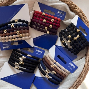 High elastic hair ties set with metal beads on display card in a woven basket