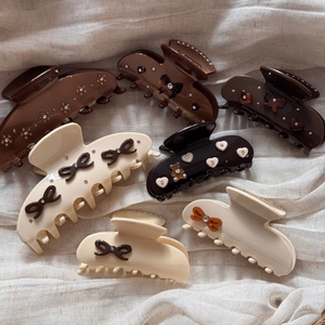 Detail of vintage acetate hair claws featuring rhinestone bows and cute bear shapes