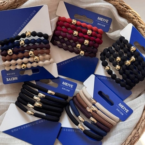 Detail of high-elastic woven hair ties with gold beads in various classic colors