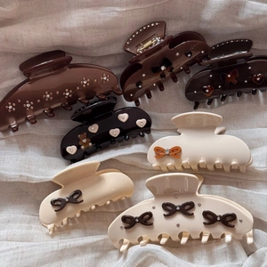 Elegant acetate bow hair claws with rhinestones in cream, brown, and black colors