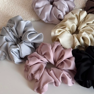 Détail de chouchous en satin surdimensionnés en gris, violet, crème, rose et noir