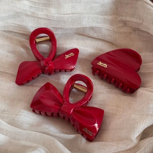 Close-up of three red acrylic hair claws with gold Barrette La France lettering