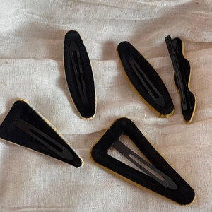 Detailed view of assorted fabric BB hair clips with textured finish and black metal snap clips