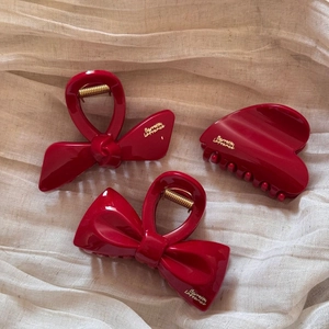 Three-piece set of deep red glossy hair claws including bow designs and fan shapes
