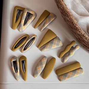 Detail of 14 pieces fabric-wrapped yellow and plaid BB hair clips in various shapes