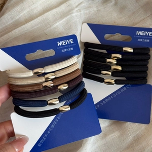 Close-up of elastic hair ties with gold metallic beads on navy display cards