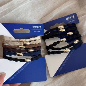 Detail of high-elasticity braided hair ties with polished gold oval beads on card