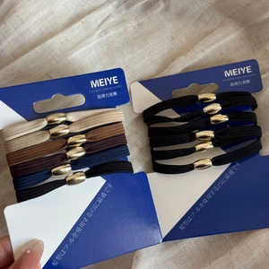 Detailed view of elastic hair ties set with gold bead accents on display cards
