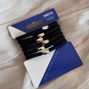 Close-up of five black high-elastic hair ties with oval metallic beads on a display card