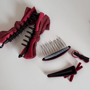 Dettaglio del set di fermagli per capelli con fiocco rosso bordeaux e pettine in metallo