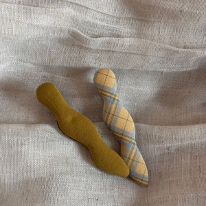 Detailed wave-shaped fabric hair clips in mustard yellow and plaid pattern set