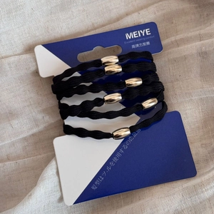 Close-up of five black high-elastic hair ties with silver metal beads on card