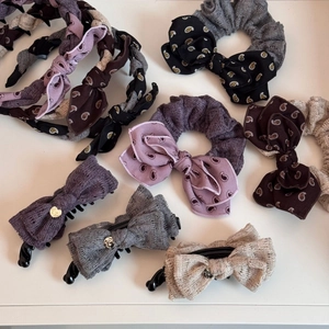 Flat lay of lace and paisley bow headbands, hair ties, and clips with gold heart charms
