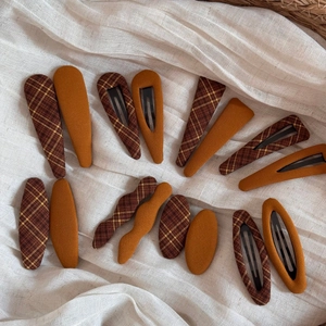 Detailed set of vintage checkered fabric BB hair clips in caramel and brown tones