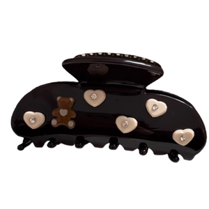 Elegant black acetate hair claw clip with cream hearts, rhinestones, and bear motif