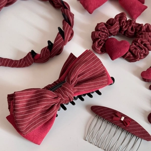 Dettaglio del set di accessori per capelli bordeaux a righe con cerchietto e mollette