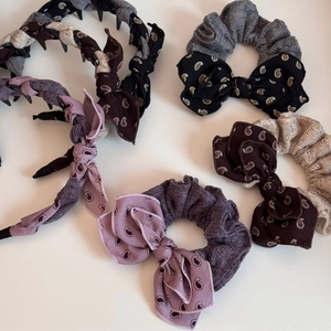 Detail of paisley printed non-slip headbands and bow hair ties in vintage dark tones