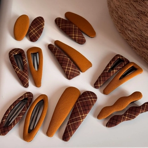 Detail of plaid fabric hair clips in yellow and brown tones with autumn vintage style