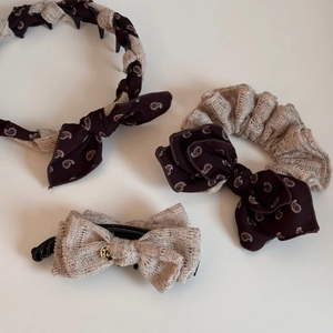 Detail view of retro bow headband and hair clip with paisley and lace textures