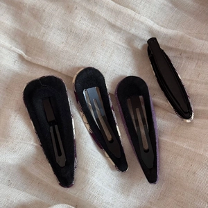 Detail showing back of four purple fabric hair clips with non-slip black lining