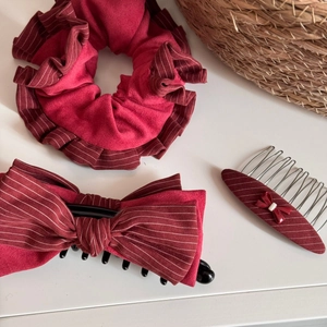 Set di tre pezzi con fermaglio per capelli in velluto bordeaux e elastico su fondo bianco