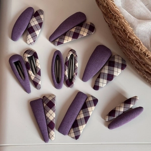 Elegant purple fabric geometric hair clip set with classic diamond pattern on white surface