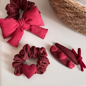 Dettaglio set fermagli per capelli con fiocco rosso, elastico in velluto e clip cuore