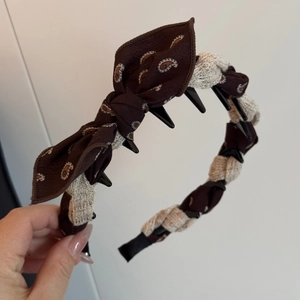 Detail showing the inner non-slip teeth and paisley bow texture on the headband