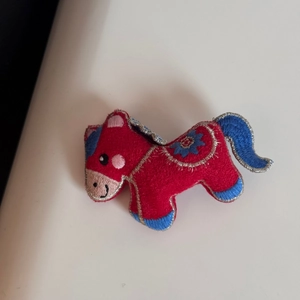 Dettaglio del cavallo in tessuto rosso con ricami blu e bordo in filo d'argento