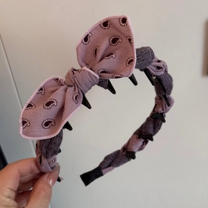 Detail view of paisley fabric bow headband featuring non-slip inner plastic teeth for hair grip