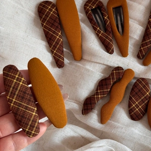 Close-up of vintage brown and plaid fabric BB hair clips with textured cotton lining