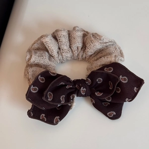 Detailed macro view of retro paisley pattern bowknot and beige textured fabric headband