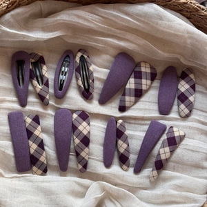 Close-up of 16-piece purple fabric hair clips set with solid and plaid patterns