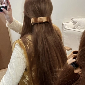 Detail view of double-layered velvet bow hair clip in golden brown for elegant hair styling