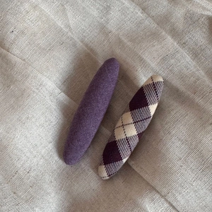 Close-up of lavender fabric hair clips with solid color and classic purple plaid pattern