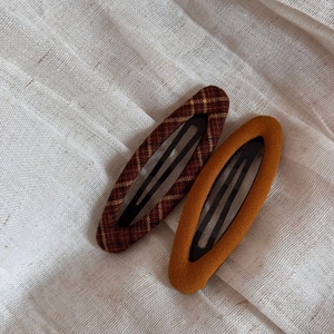 Detailed macro view of vintage brown plaid and mustard yellow fabric wrapped hair clips
